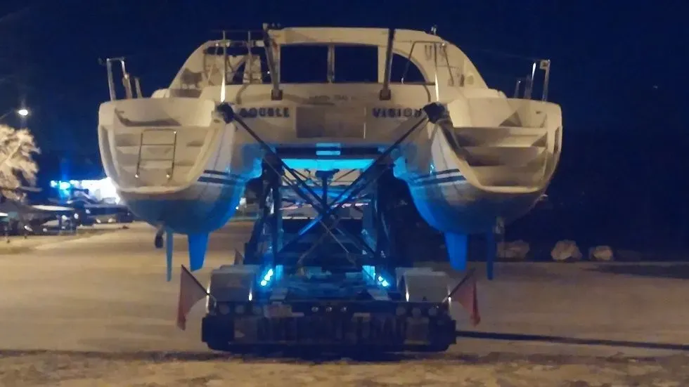 A Lagoon 380 catamaran being transported at night by Safe Harbor Haulers who specializes in boat transport.